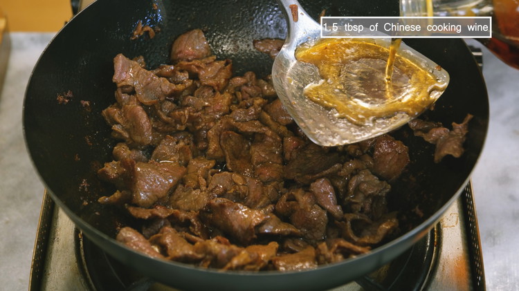 Image of Add a drizzle of Chinese cooking wine from the side of the wok and mix well. A little bit of the liquid helps to deglaze the bottom of the wok as well as lowering the temperature so that the beef...