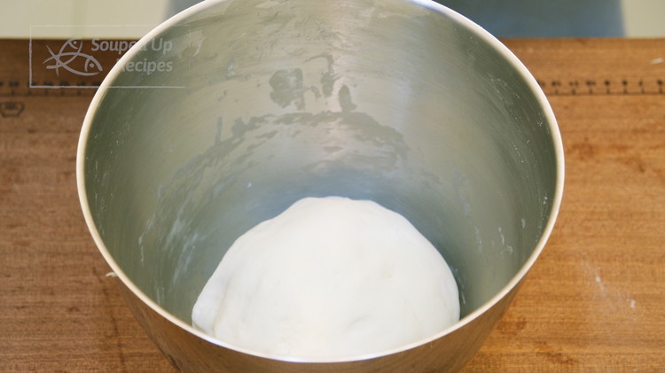 Image of Once the dough becomes smooth and elastic, roughly shape it into a round ball. Cover it and let it proof for 1 hour or until it doubles in size.