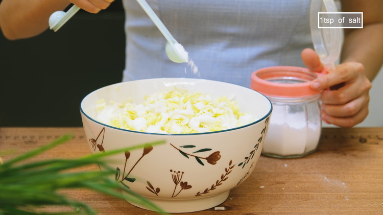 Image of Roughly dice 400g of napa cabbage. Season it with 1 tsp of salt and toss thoroughly. Let the napa cabbage sit on the side for 20 minutes to allow the sodium to draw out some moisture. 