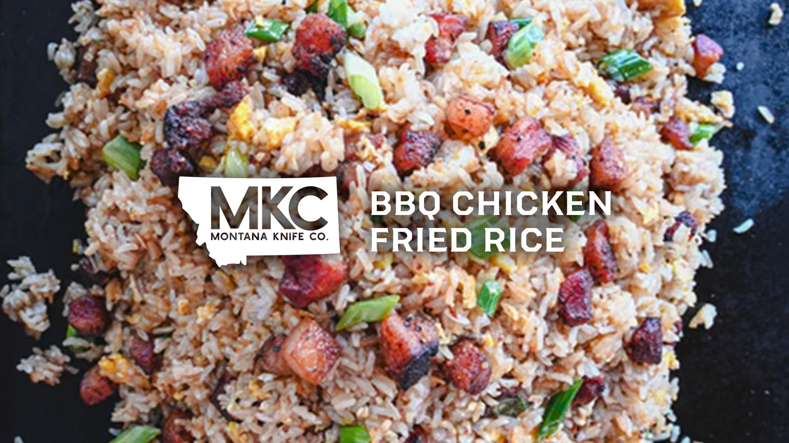 Close-up view of BBQ chicken fried rice with eggs, scallions, soy sauce, sesame oil, butter, and seasoning.