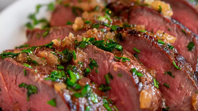 Grilled picanha steak with a crispy seared edge and fresh herbs