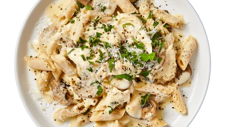 Bowl of pasta tossed with roasted veggies, herbs, and garlic butter