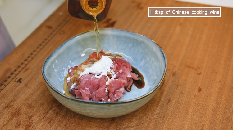 Image of Slice the pork shoulder meat thinly. Then marinate the pork with 1/2 tbsp of soy sauce, 1/2 tsp of dark soy sauce, 1/4 tsp of finely ground white pepper, 1.5 tsp of cornstarch, and 1 tbsp of Chinese cooking wine....