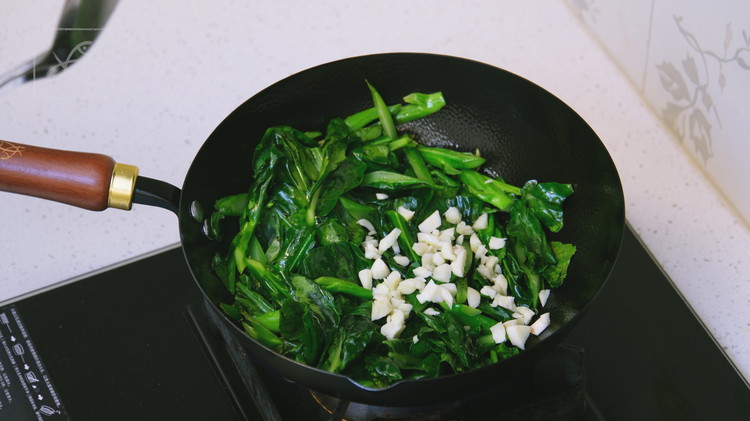 Image of Turn the heat to medium and preheat the wok for 40 seconds. Add oil and the Gailan stems. Stir fry for 2 minutes because they take a bit longer to cook. Toss in the leafy parts and mix until the...