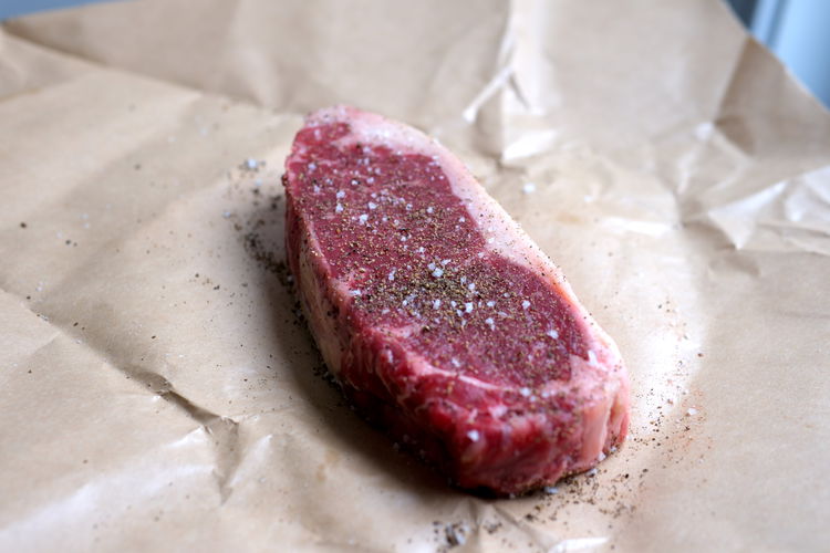 Image of Generously salt and pepper meat to prepare for grilling