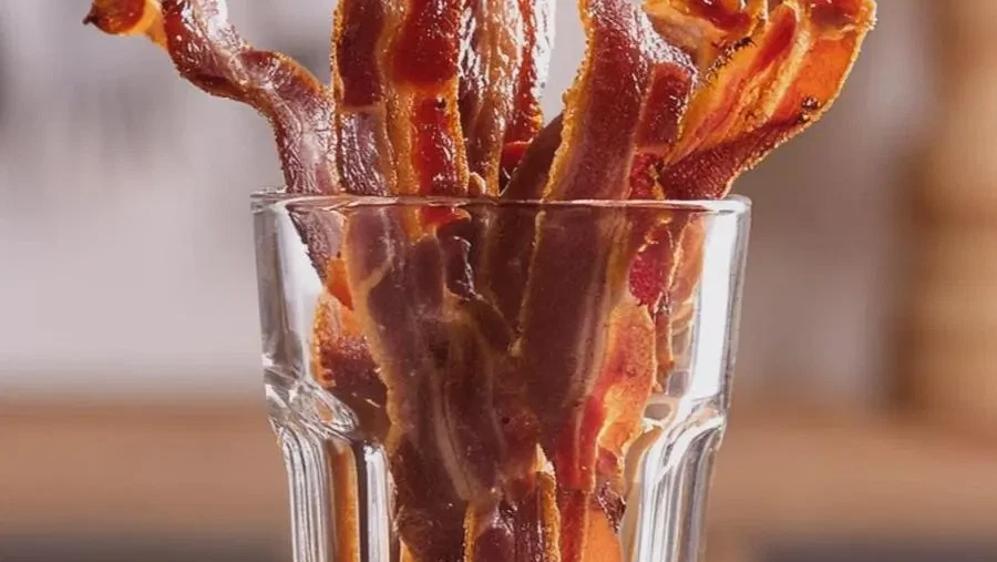 Hot Honey Dust Candied Bacon in a glass to be served