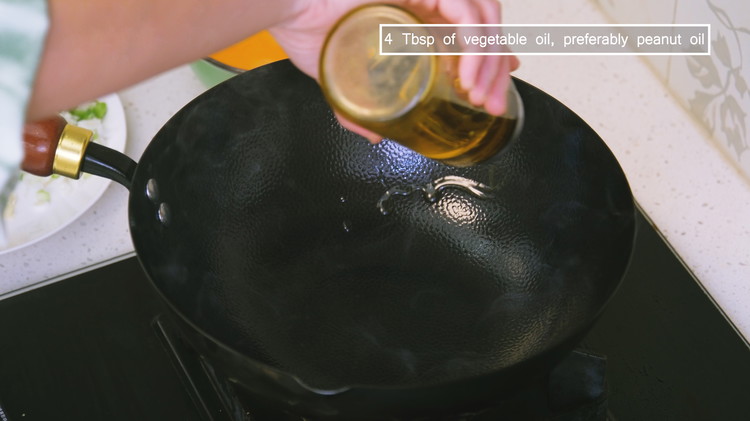 Image of When the wok starts to smoke, that's the sign to add a generous amount of oil. Do not pre-heat the wok for too long—if the metal gets too hot, the oil could ignite as soon as it touches the wok.
