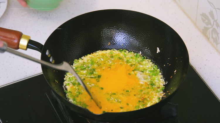 Image of Pour in the beaten eggs and stir well. This way, every bite of egg is infused with the scallion and garlic aroma, making it extra fragrant.