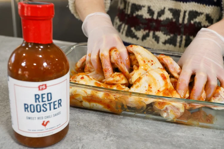 Image of Place chicken wings in a 9x13-inch glass baking dish.  Pour 1 cup of Red Rooster Sweet Chili Sauce over wings, coating them completely. Cover and refrigerate for 2 hours to allow the sweet, tangy marinade to penetrate the meat.