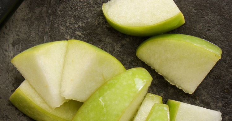 Image of 3️⃣ Prépare les pommes.Épluche, coupe en deux, évide. Arrose d’un trait de citron. Dispose serré dans le caramel, bombé vers le fond (cœur vers le haut). Le serrage = joli motif au renversé. 🍏➡️🍮