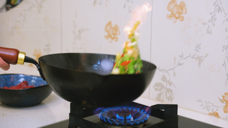 Image of Turn the heat to maximum and pre-heat the wok until smoking hot. Add a big drizzle of oil and toss in the Chinese celery stems, diced garlic, Thai bird eye chilies, ginger, and scallion whites. Stir over high heat for...