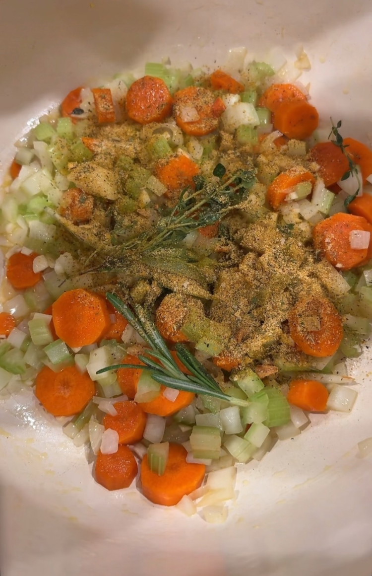 Image of Dice carrots, onions, celery and mince garlic. Melt 2T butter in a pot and add in veggies, fresh herbs, and garlic. Season with 2t Chicken Soup seasoning. Saute on medium high heat for 5 mins.