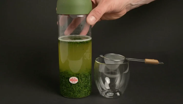 Image of Place a tea strainer over a glass or carafe and pour the tea through to separate the leaves.
