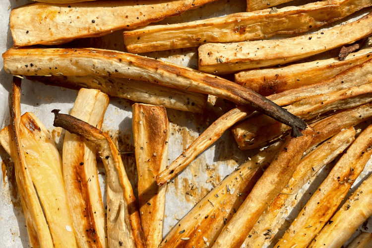 Image of Place parsnips on the parchment-lined pan and bake in oven...