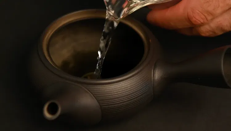 Image of Fill the kyusu and cups with hot water to warm...