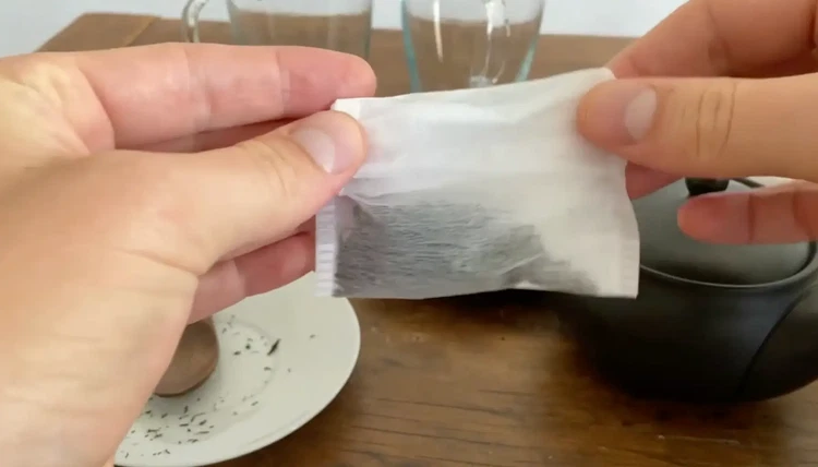 Image of Close the tea bag by folding the top flaps securely. Avoid glue or staples, which can affect taste and safety.