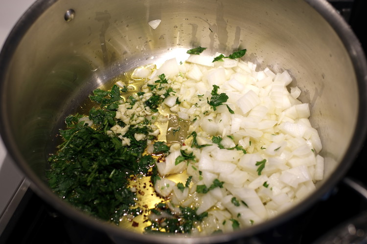 Image of Add olive oil to pot over medium heat.  Once hot (don’t let it smoke—should just be a few seconds) add onion, garlic, red pepper flakes, parsley, and the broken bay leaf.  Stir