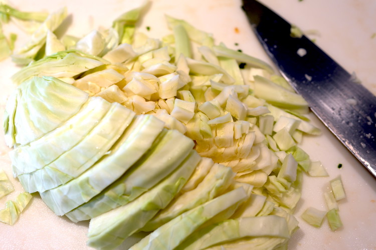 Image of Cut and roughly chop or shred half of your remaining cabbage head (reserve the other half for another use)