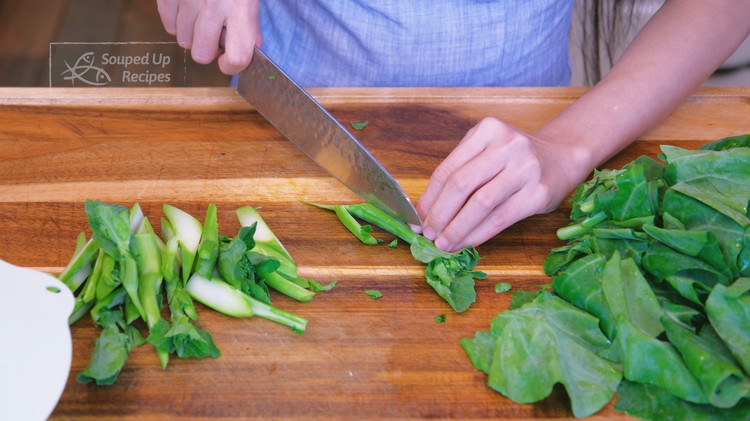 Image of Cut the Chinese broccoli on a 45-degree angle into 2-inch-long stalks. Separate the leaves and the stems because they will go into the wok at different times. If using Western broccoli, cut it into bite-sized florets.