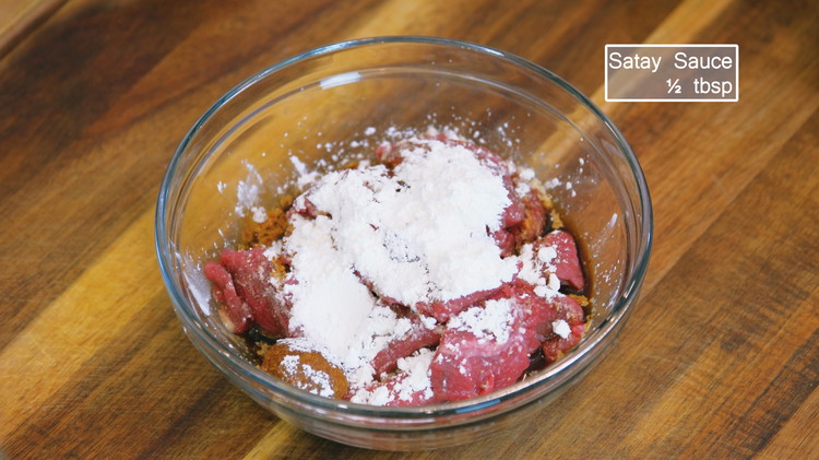 Image of Cut the beef across the muscle grains into ⅛-inch thick slices. Place the beef in a mixing bowl and add the baking soda, ground white pepper, dark soy sauce, Chinese cooking wine, cornstarch, and satay sauce. Mix well.
