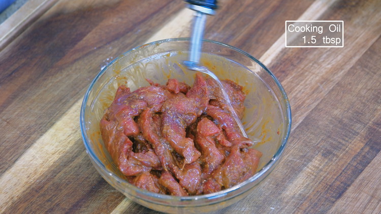 Image of Add 1.5 tablespoons of cooking oil and mix to coat the beef; this will prevent the slices from sticking, making it easier to stir-fry later. Set the beef aside for 15 minutes.