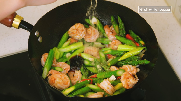 Image of Add the blanched asparagus and shrimp. Season them with 1 tbsp of soy sauce and 1/2 tbsp of oyster sauce, and some finely ground white pepper. Stir well and we are done.