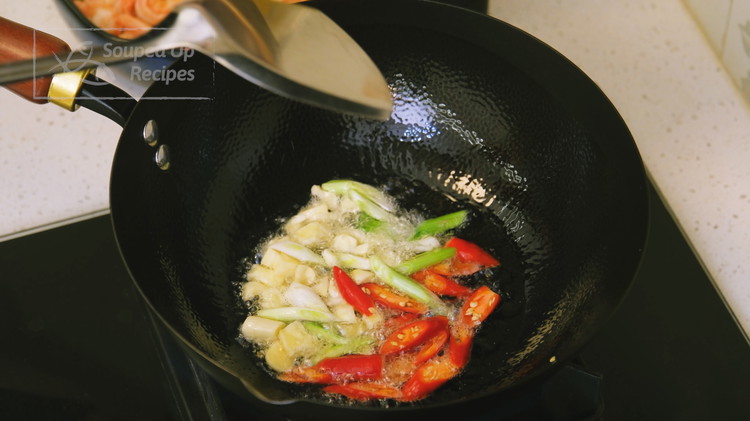 Image of Preheat a wok over medium heat for 20-30 seconds. Add 2-3 tbsp of oil. Toss in the diced garlic, white parts of the scallion, and Thai bird eye chilies. Saute them for 15 seconds. If you don’t eat spicy food,...