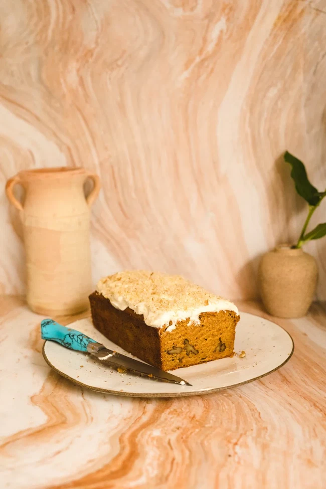 Image of Spiced carrot loaf with maple cream cheese frosting & crushed walnuts