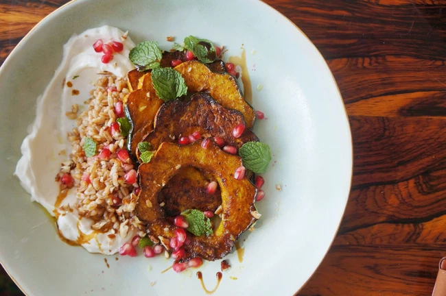 Image of Curry Roasted Acorn Squash With Yogurt, Farro Tabouli, Fresh Mint & Pomegranate