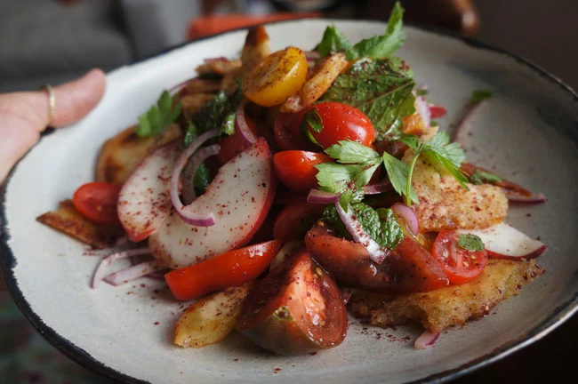 Image of Sumac pita, tomato & peach panzanella with fresh mint & parsley