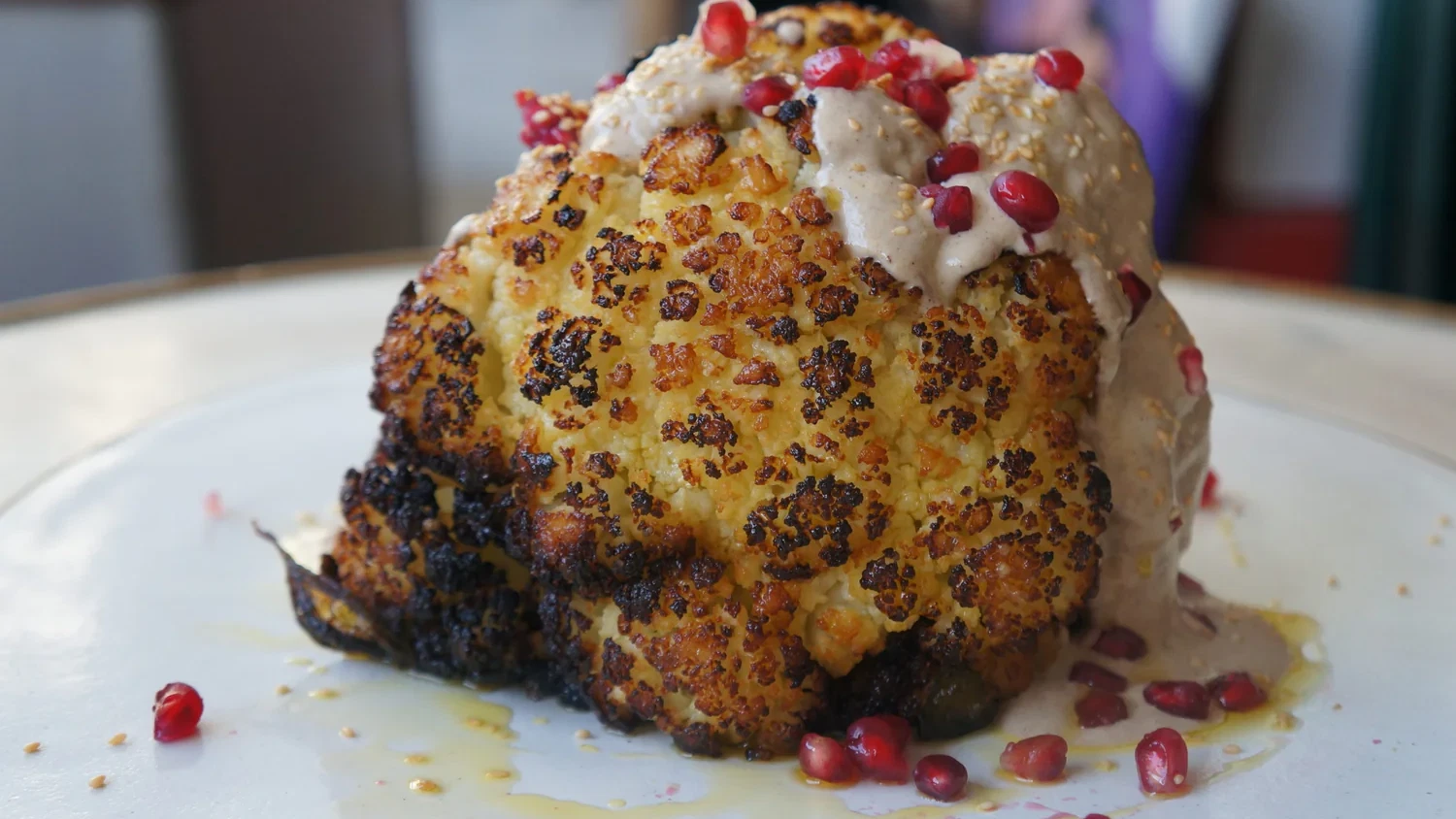 Whole Head Of Roasted Cauliflower with tahini, toasted sesame seeds, pomegranate and fresh parsley-image