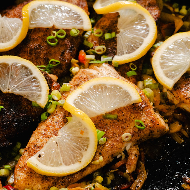 Image of Remove fresh thyme sprigs and return fish to the pan and add a lid to steam the fish and warm it back up as needed. Check for seasoning and adjust if necessary. Garnish with minced scallions and a lemon slice.