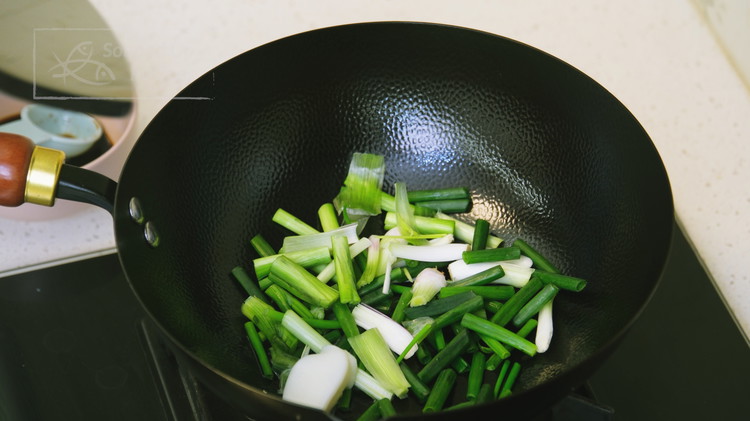 Image of Cut the bottom parts of the scallions into 2-inch-long pieces and add them into a wok along with 1 tbsp of pork lard. Carefully fry the scallions over medium-low heat until golden and crispy.