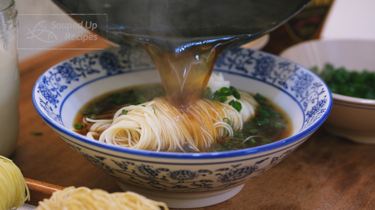 Image of The broth should come to a boil by now. Skim out the scallions and pour the broth it into the noodles. As the heat melts the lard, you’ll smell the wonderful aroma of scallion mingling with pork fat—it’s warm, rich,...