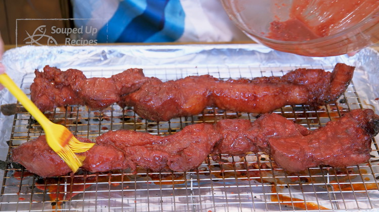 Image of Take the char siu out of the oven and brush the leftover marinade on the pork. Flip over and brush the other side.