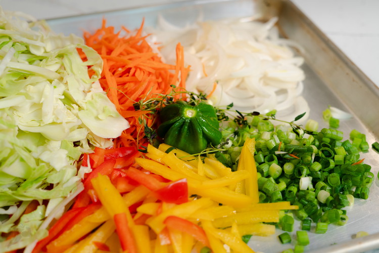Image of Peel tough outer leaves from cabbage. Slice in quarters and remove the core. Shred the cabbage (if you have a mechanical way to do this it may make your life easier. Slice your bell peppers, carrots, and onions and green...