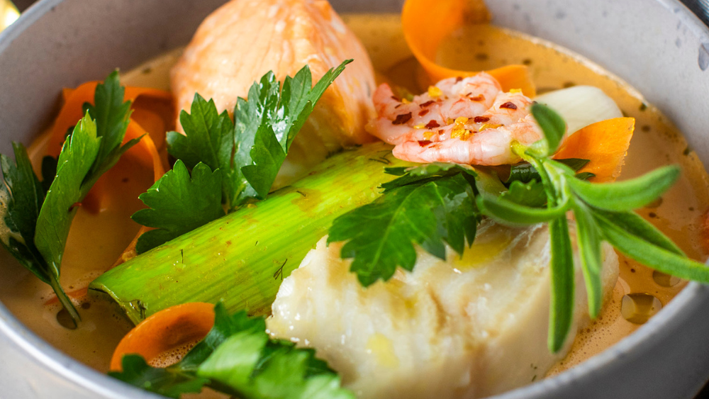 Image of Cremet fiskesuppe med torsk, laks og store rejer.