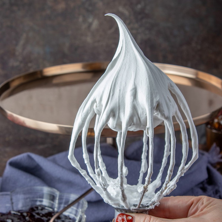 Image of Dissolve the cornflour in the vinegar and vanilla extract, drizzle
over the meringue and fold in gently. The meringue is ready when it forms a
nice peak on the tip of your whisk as you pull it out.