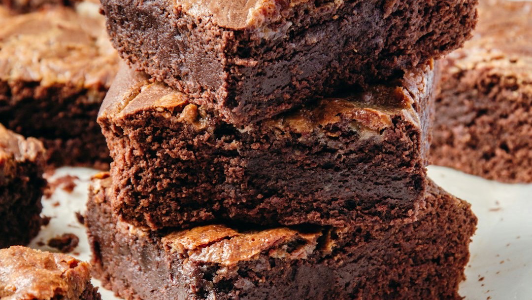 Thick, square fudge brownies with a deep chocolate color arranged neatly.