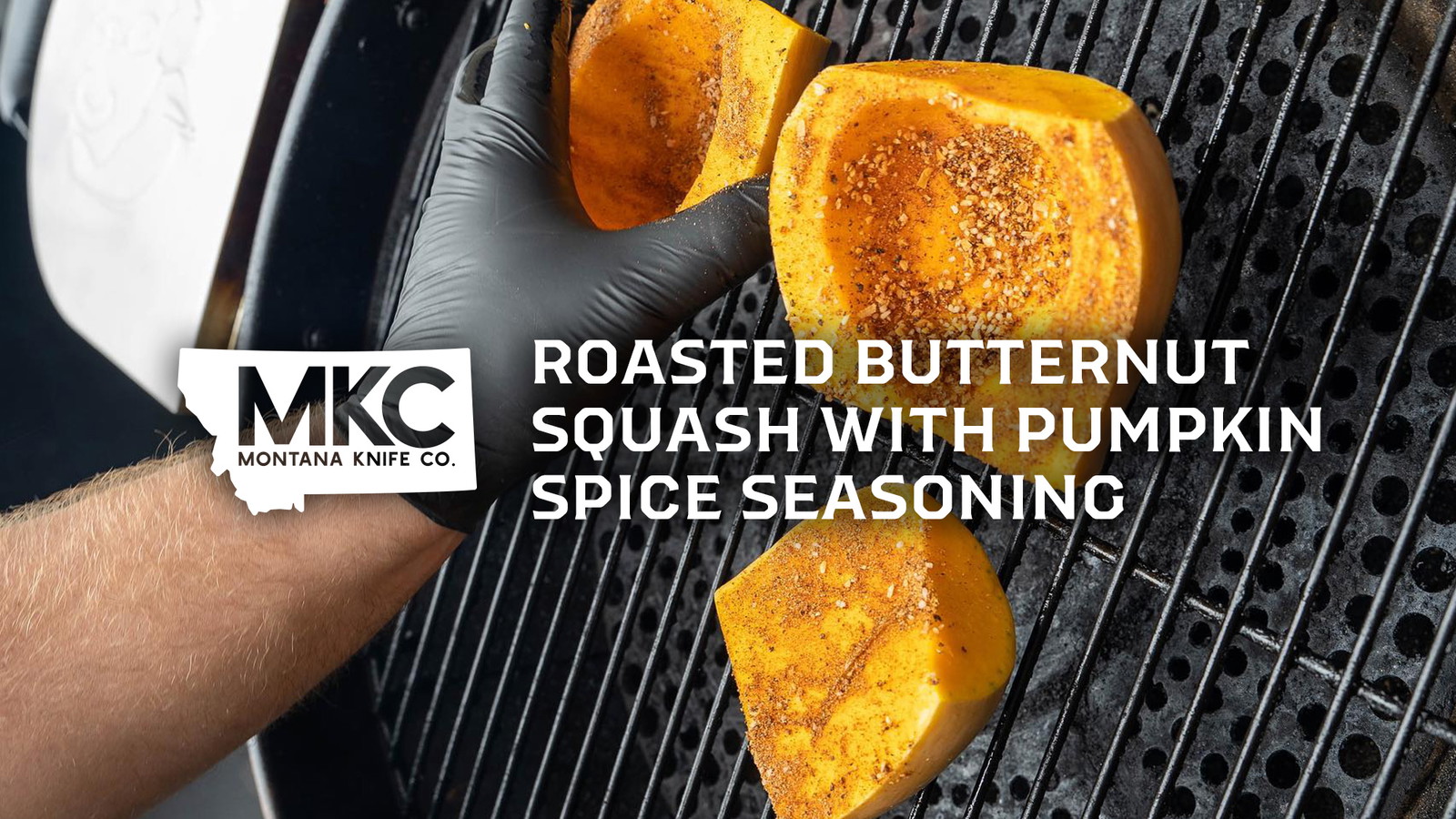 Three butternut squash slices on a grill with a gloved hand turning one for even roasting.