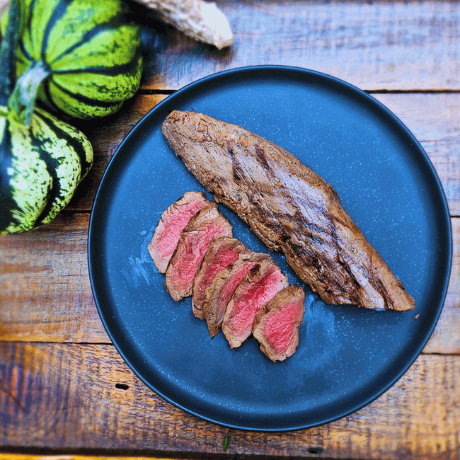 grilled Elk tenderloin sliced on black plate