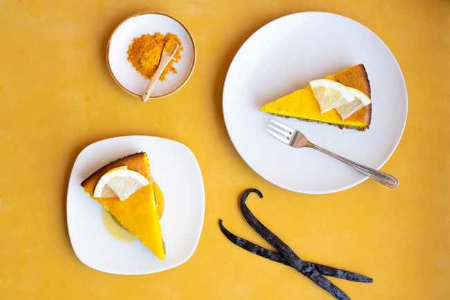 Romige kurkuma-citroen cheesecake met witte chocolade, frisse citroen en een goudgele kleur door pure kurkuma