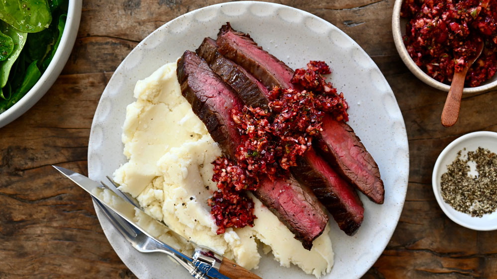 Flank Steak with Cranberry Salsa on a white plate 