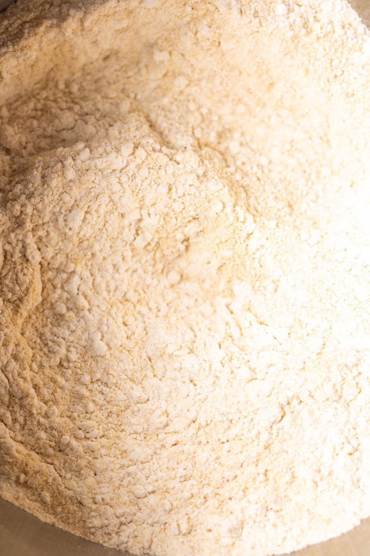 Image of Mix together flours, yeast and salt into a bowl.