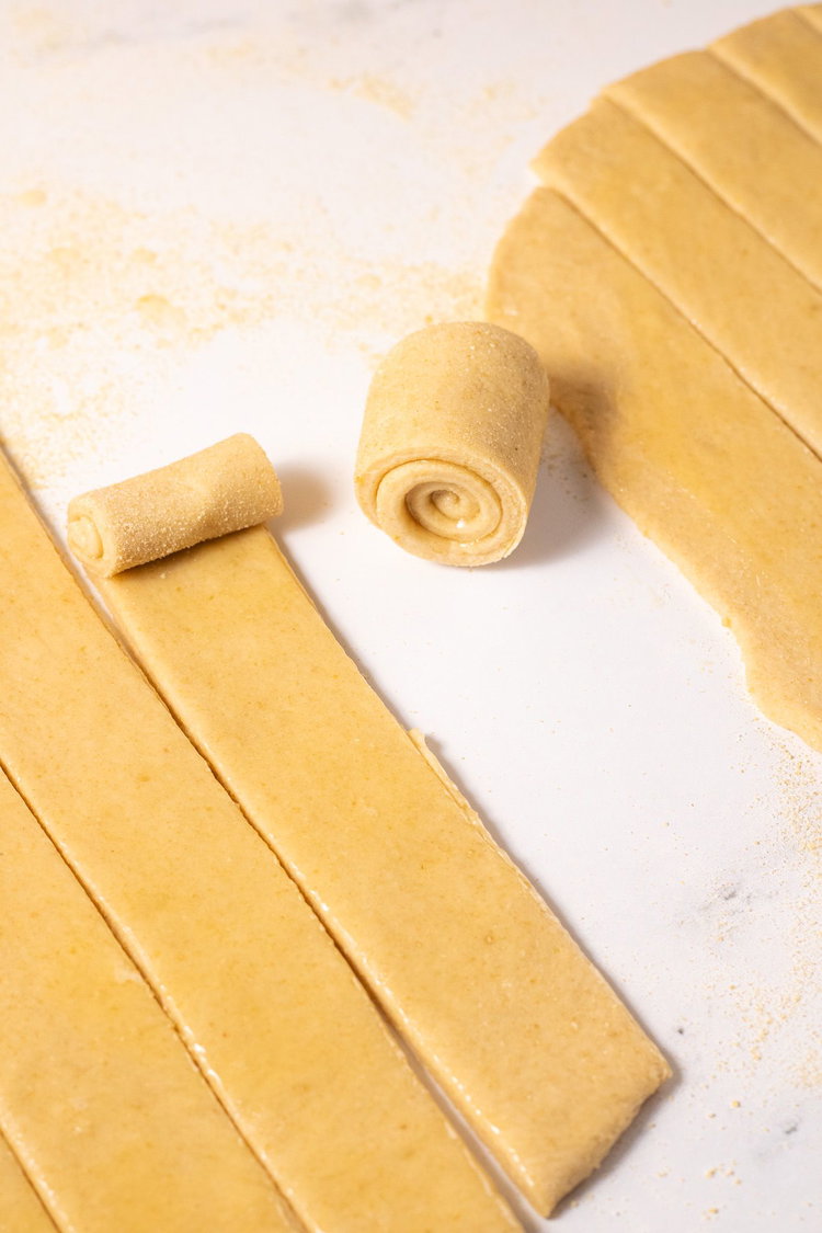 Image of Using a pizza cutter, cut your dough into strips. Roll...