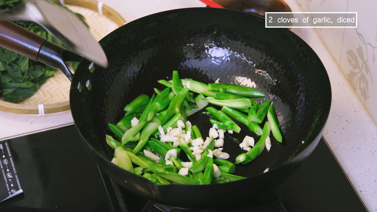 Image of Turn the heat to medium and preheat the wok for 20 seconds. Add a drizzle of oil and swirl it around. Toss in the gailan stems and stir for a 2-3 minutes or until cooked through. Add the garlic and...