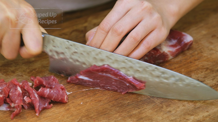 Image of Slice the beef into 1/8 of an inch thick pieces. I am using flank steak. Other cuts, such as strip steak, ribeye, and sirloin will also work. 