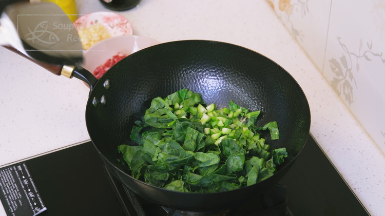 Image of Turn the heat to high and preheat the wok until smoking hot, which will take about 30 seconds. Add a big drizzle of oil. Toss in the diced gailan and stir quickly for a minute.