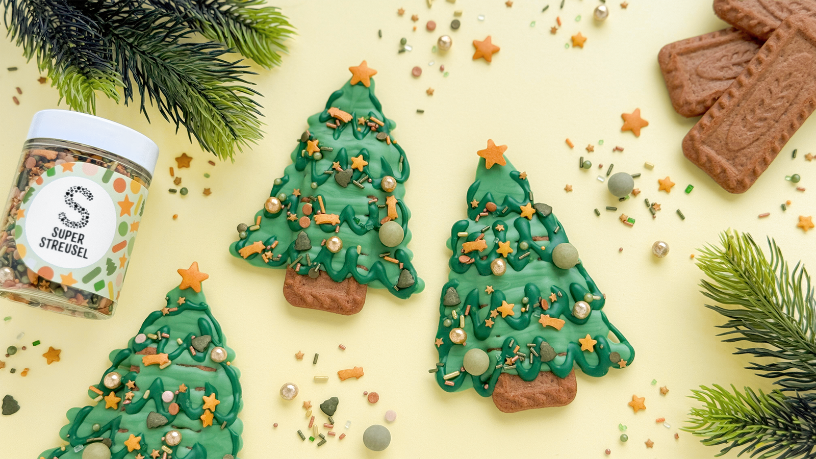 Spekulatius-Kekse als Weihnachtsbäumchen dekoriert: mit grünem und dunkelgrünem SuperDrip bemalt, mit StreuselMix SchnuppiSchnupp bestreut und Stern-Deko auf der Spitze.