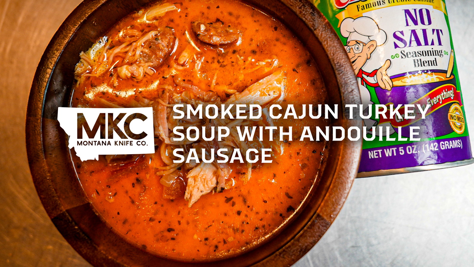 Bowl of Cajun turkey soup beside a bottle of seasoning blend.